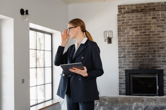 a-person-holding-a-clipboard-while-inspecting-a-home